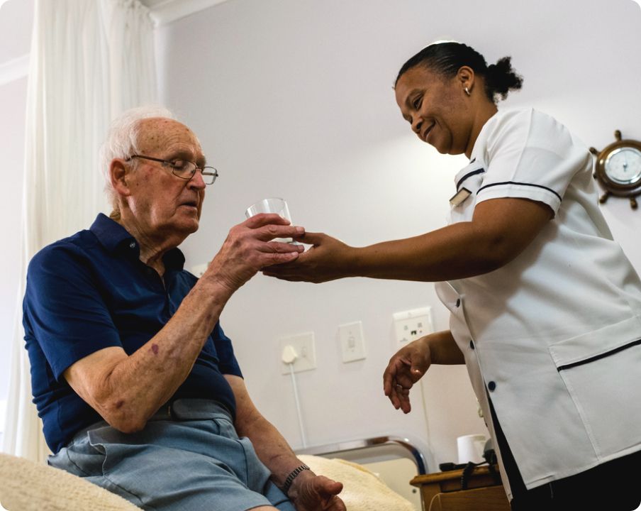 elderly man given glass of water